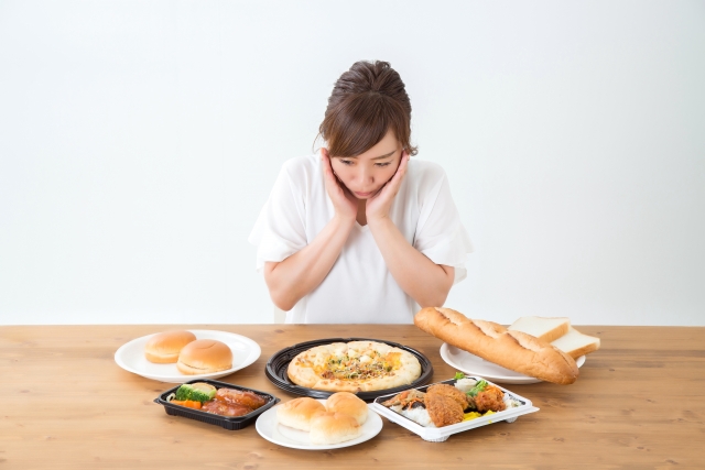 ダイエットの妨げとなりやすい、たくさんのファストフード（高カロリー・高脂質・高脂肪な料理）と、食べ過ぎ、摂取カロリーが過剰になってしまうことを悩む女性