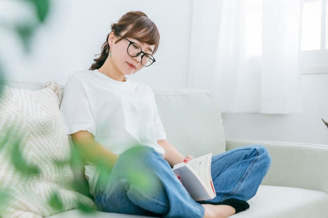部屋で読書をしくつろぐインドアな女性