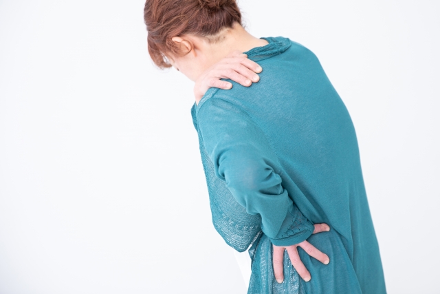 肩や腰を抑えている女性（痛み、しびれ、不調や違和感など）