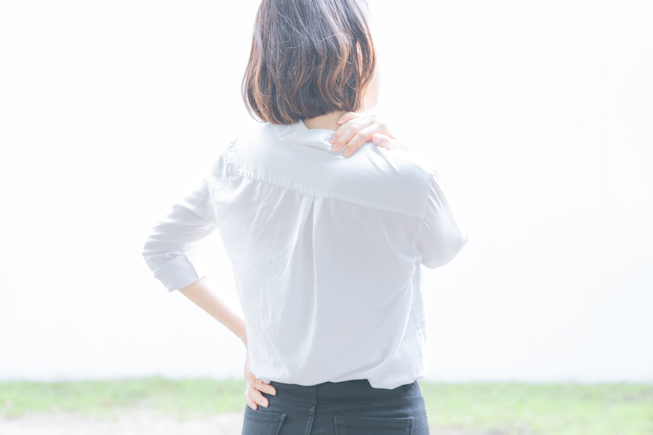 首、肩を押さえている女性（肩こり・首や肩、背中の痛み・背中や肩周りの血行不良）