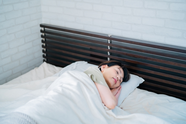 ぐっすり眠れている女性（日中に適度な運動をすると、メラトニンの材料であるセロトニンの分泌が増え、質の高い睡眠につながります）